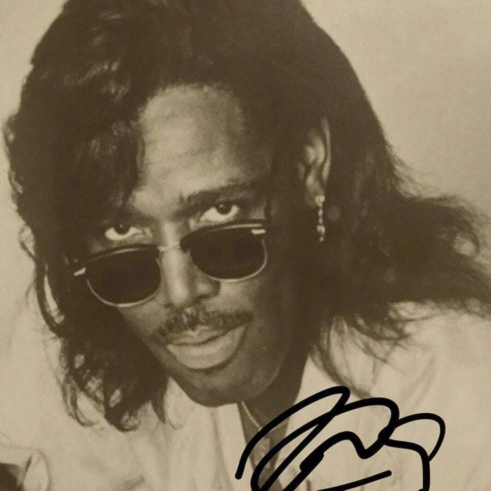 An archival portrait of Wayne Collins Sr. wearing sunglasses